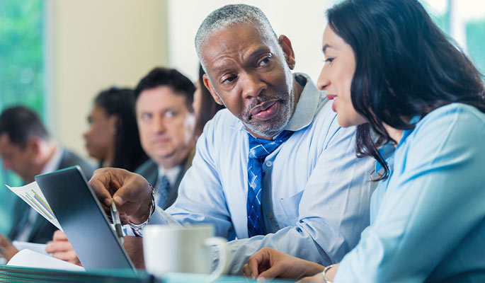 Older businessman working with a young professional woman