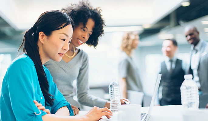 Team members consider diversity insights on a laptop in an office setting