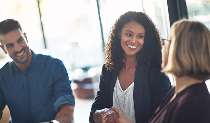 Diverse team in a business meeting, Two women shaking hands.