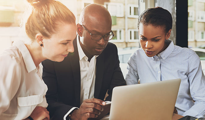 Diverse team reviewing information on a laptop