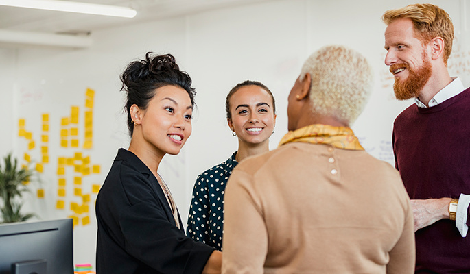 A group of employees discuss their work in an inclusive workplace environment