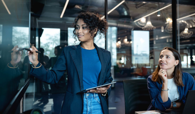 A mentor discusses a workplace issue on an interactive whiteboard