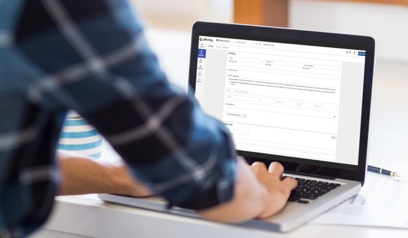 Photograph showing view of an employee standing at a laptop and using the talent decisions software module interface